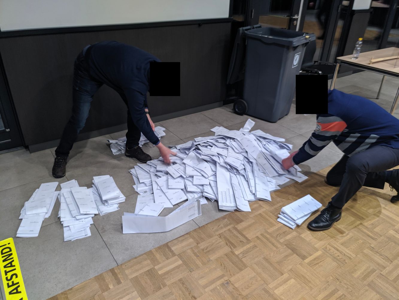 Polling station members creating stacks of ballots shortly after opening the ballot box